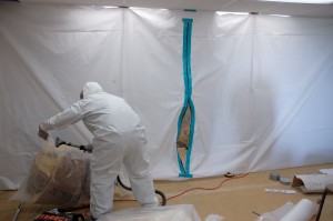 Man in hazmat suit removing mold from a home.